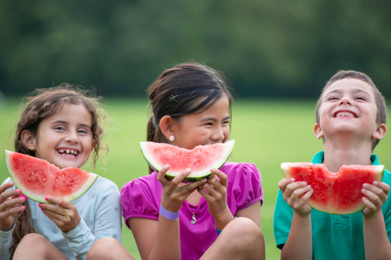 Happy kids eating watermelon