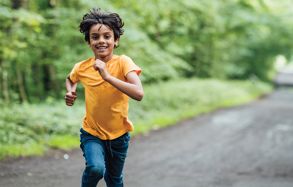 Boy in a yellow shirt running on a path