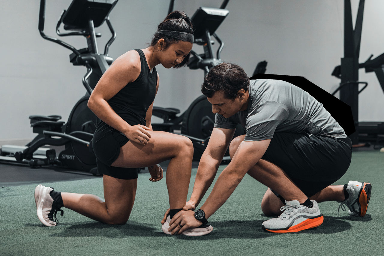 Sports medicine specialist evaluating and treating an athlete's ankle during a rehabilitation session.