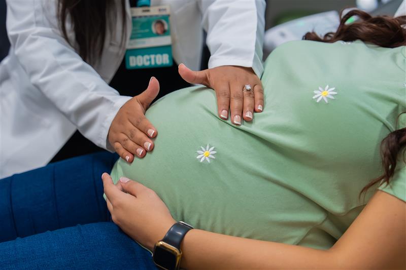 Doctor examines pregnant mom.