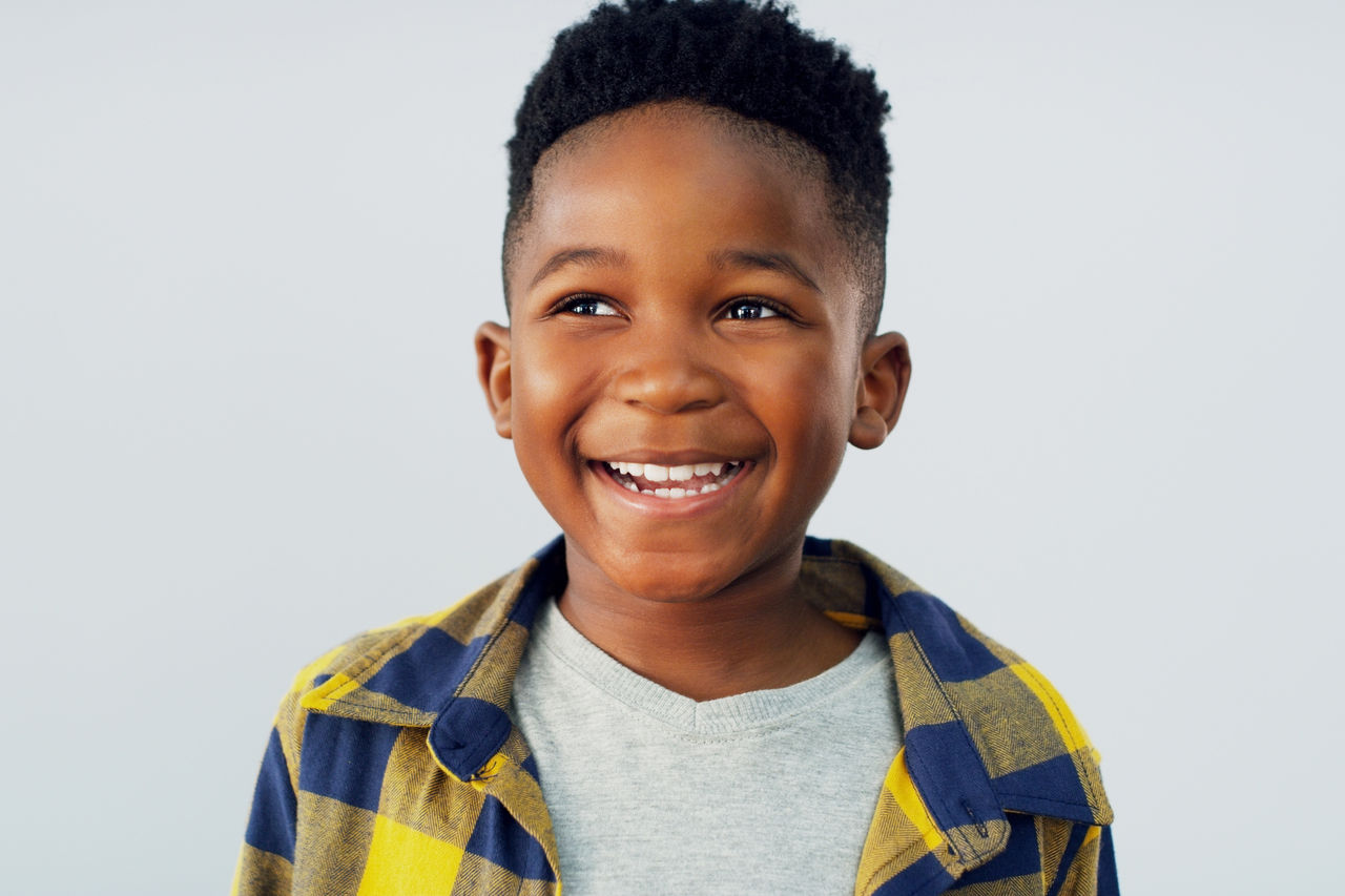 Fotografía de un niño adorable posando sobre un fondo blanco