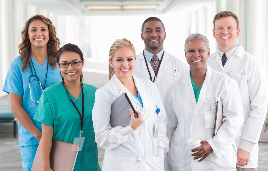 A group of nurses and doctors in a group smiling. 