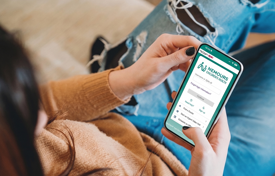 Looking over woman's shoulder while she holds her mobile phone, reading the screen while sitting down