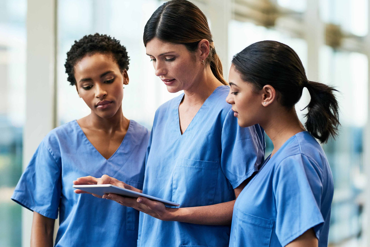 Nurses collaborating in hallway