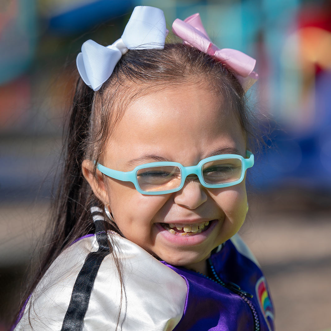 Ariana shares her kidney and liver transplant journey. Ariana is shown smiling and wearing her glasses in the sunshine as shares her kidney and liver transplant journey.