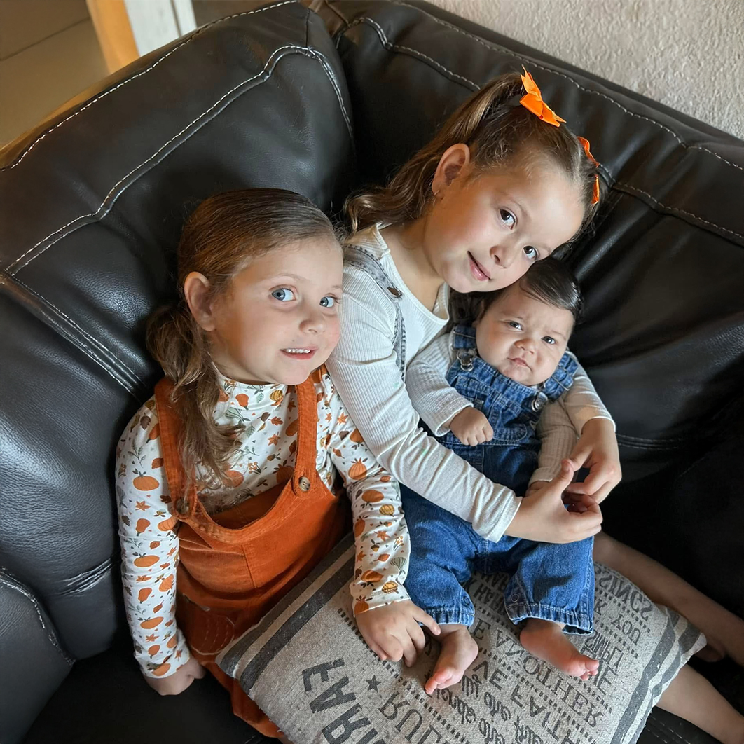 3 niños sentados en una cómoda silla para la historia de Zoe y Brooklyn