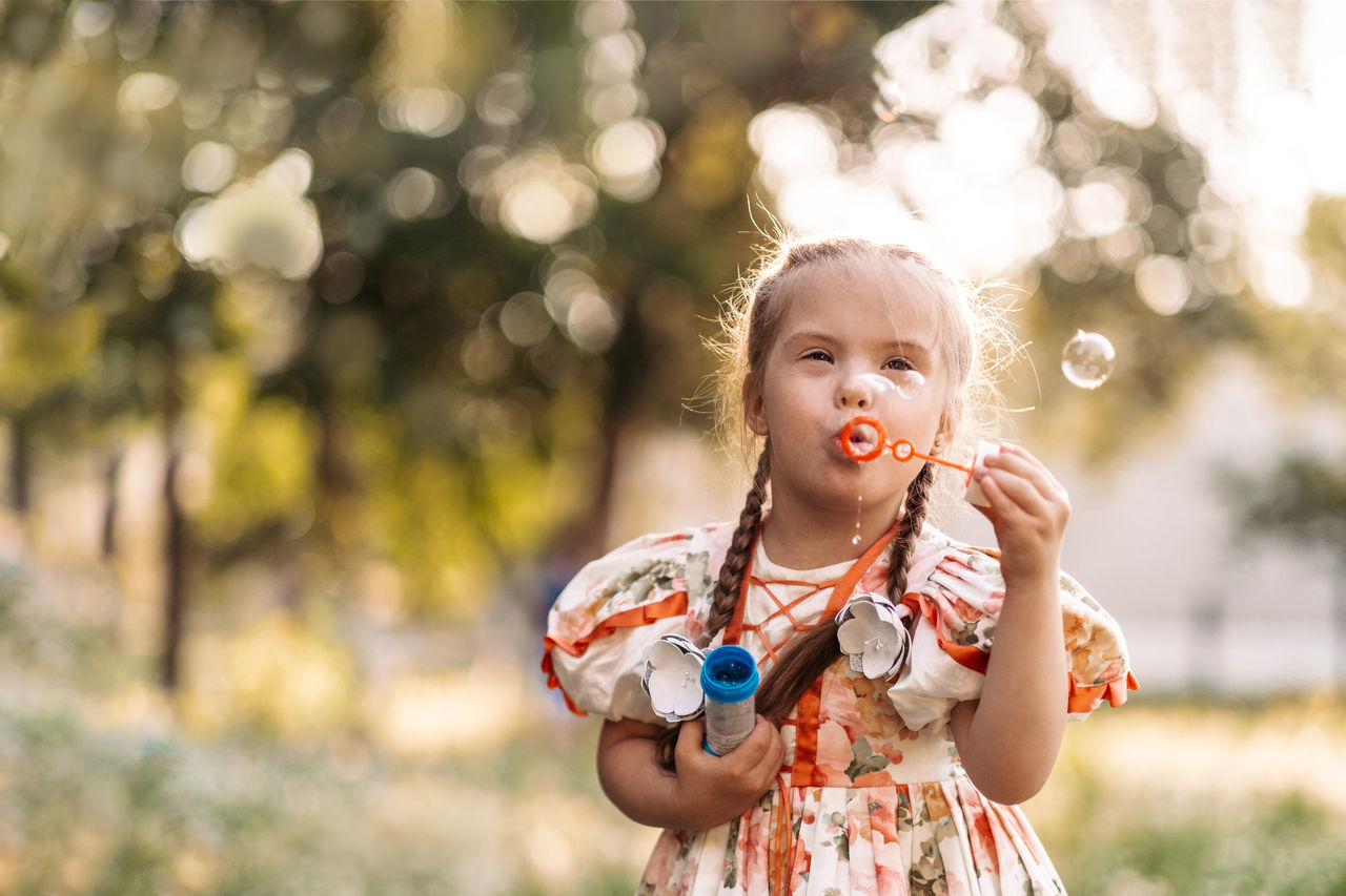 Girl outside blowing bubbles 
