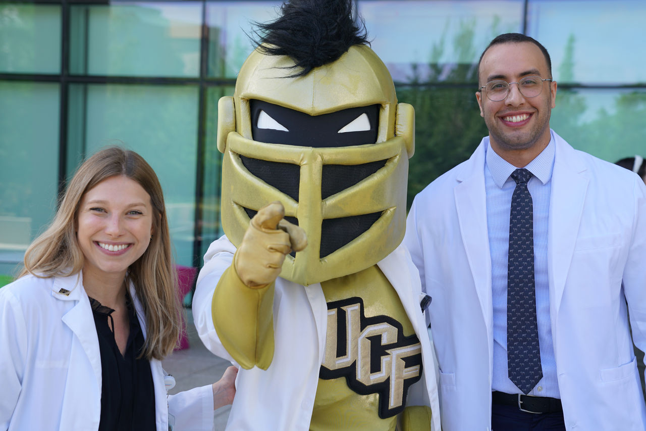 Dos proveedores de pie con la mascota del FCU.