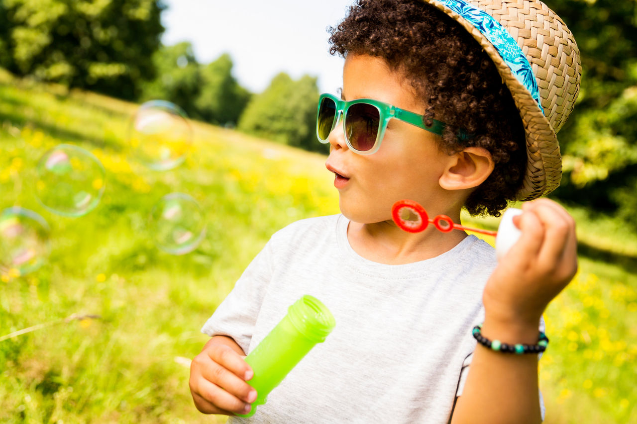 Boy blowing bubbles outside