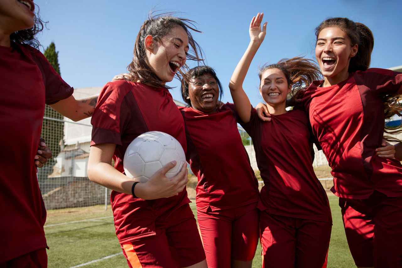 Girls' soccer team celebrating victory.