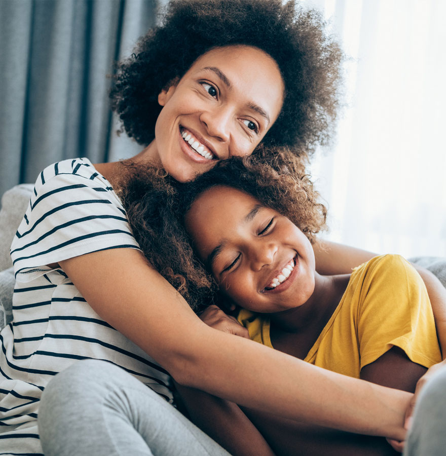 Mother hugging daughter.