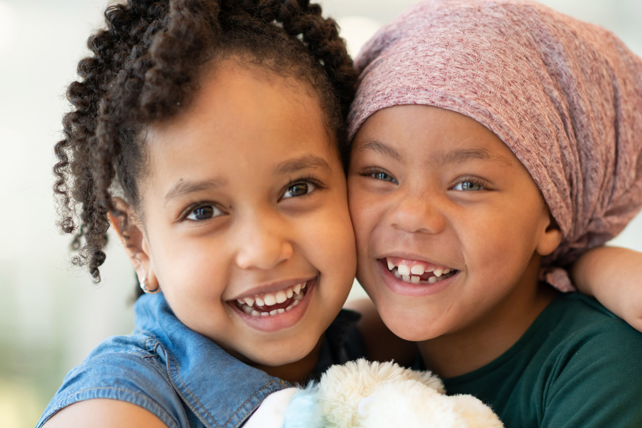 Two young girls hugging and smiling at the camera
