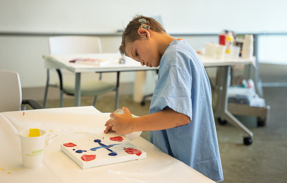 Child doing paint art  at the cochlear implant summer camp