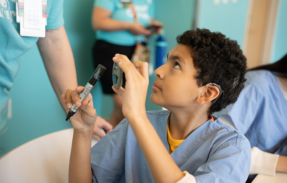 Child holding a cochlear implant 