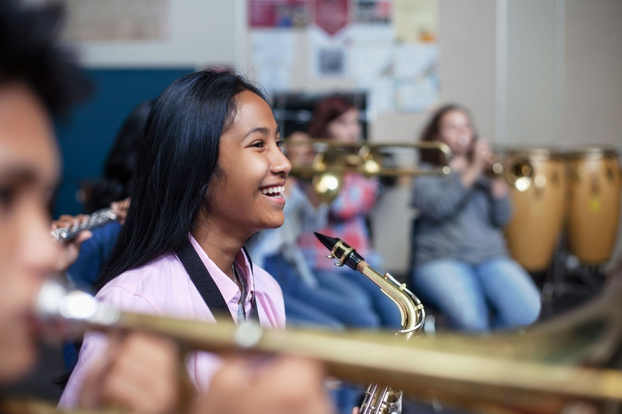 Student musician playing trumpet with band.