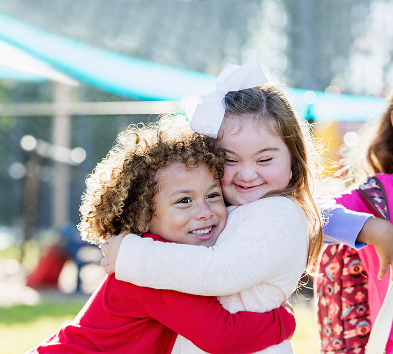 Two girls hugging, one is special needs Two girls hugging, one is special needs