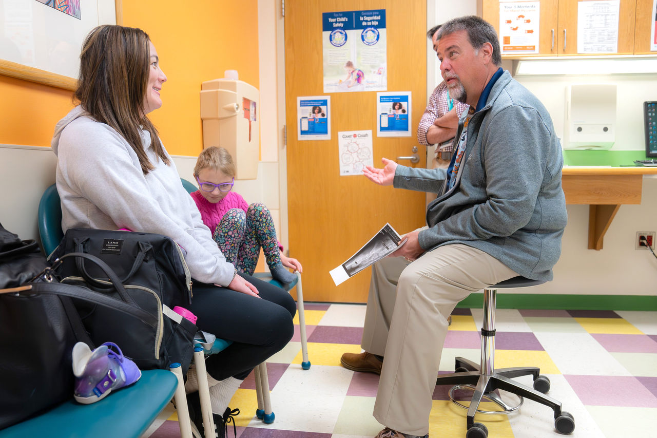Doctor discussing gait lab with mother and daughter Doctor discussing gait lab with mother and daughter