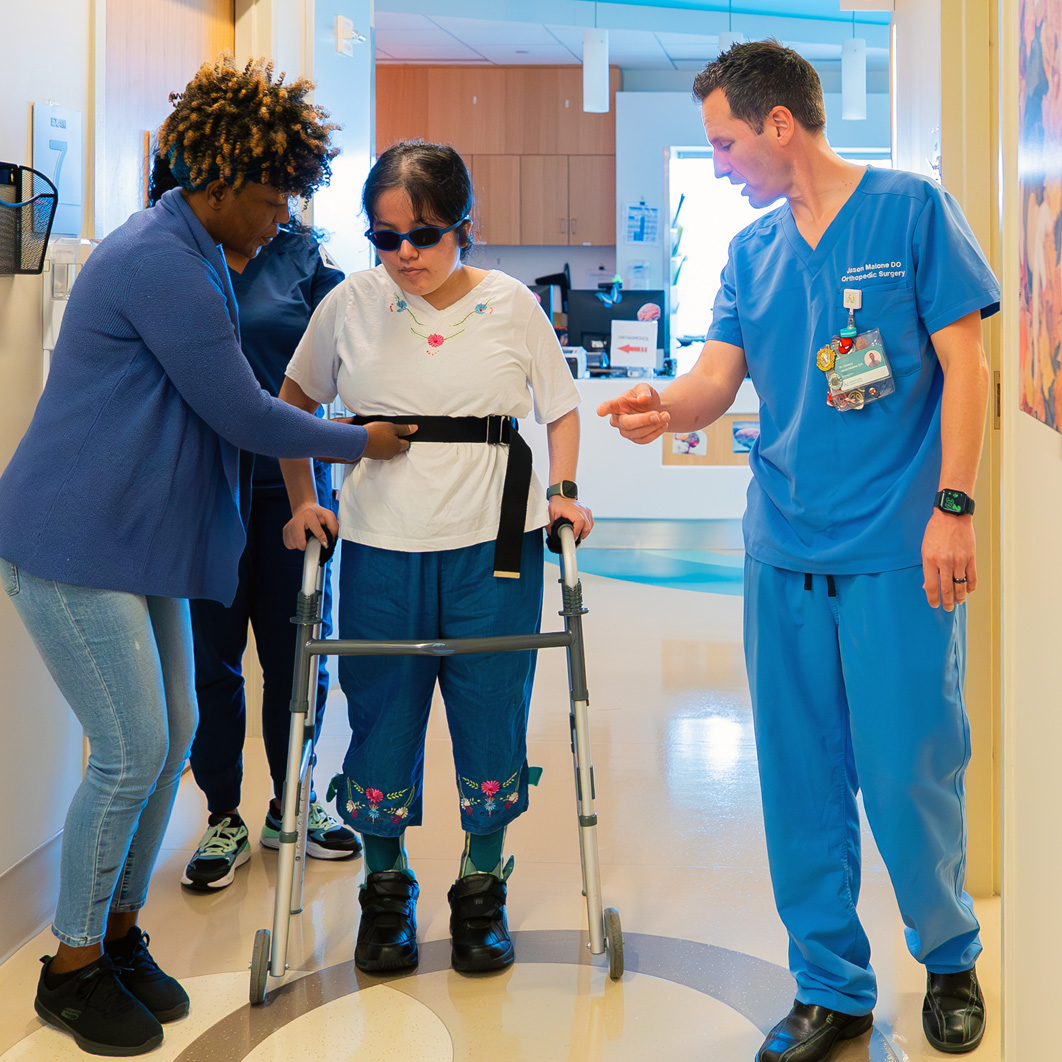 Staff walking with patient using a walker