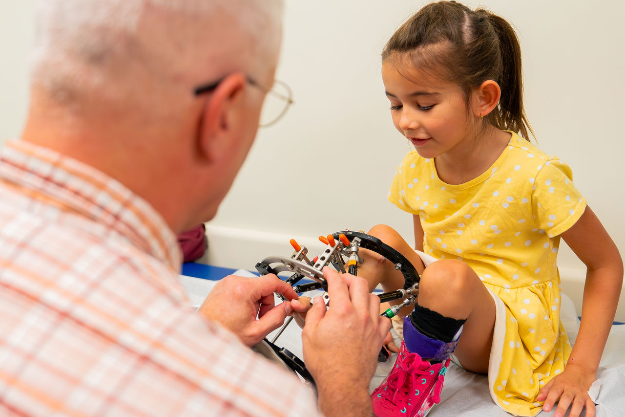 Child with doctor and limb correction device