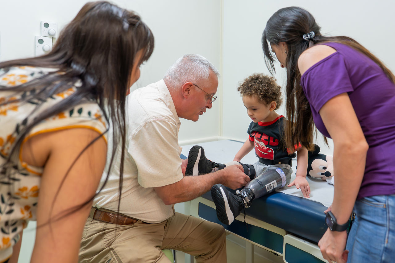 Child and family with doctor and limb correction device