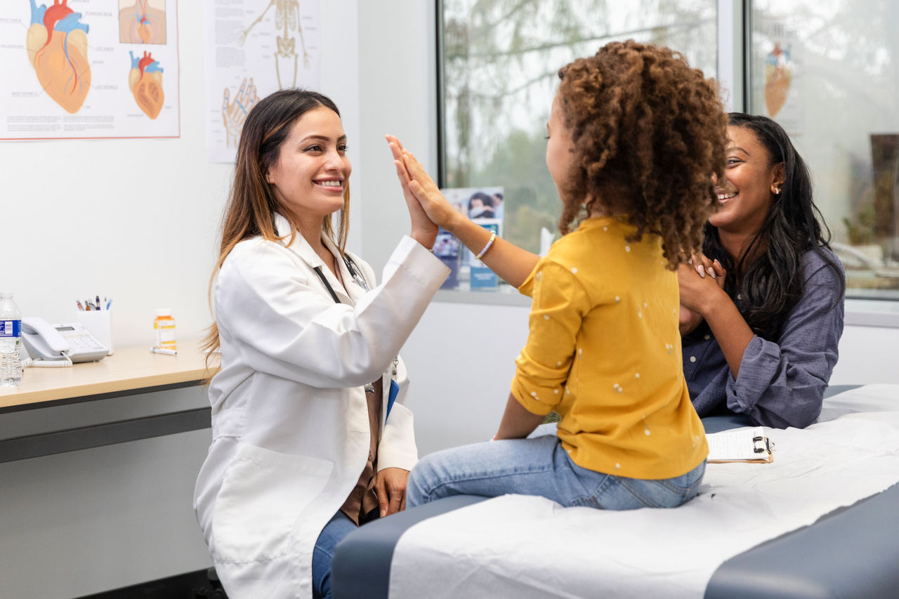 una paciente que choca los cinco con una médica 