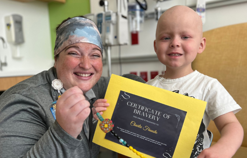 Charlie, un paciente con linfoma, sostiene un certificado de valentía.