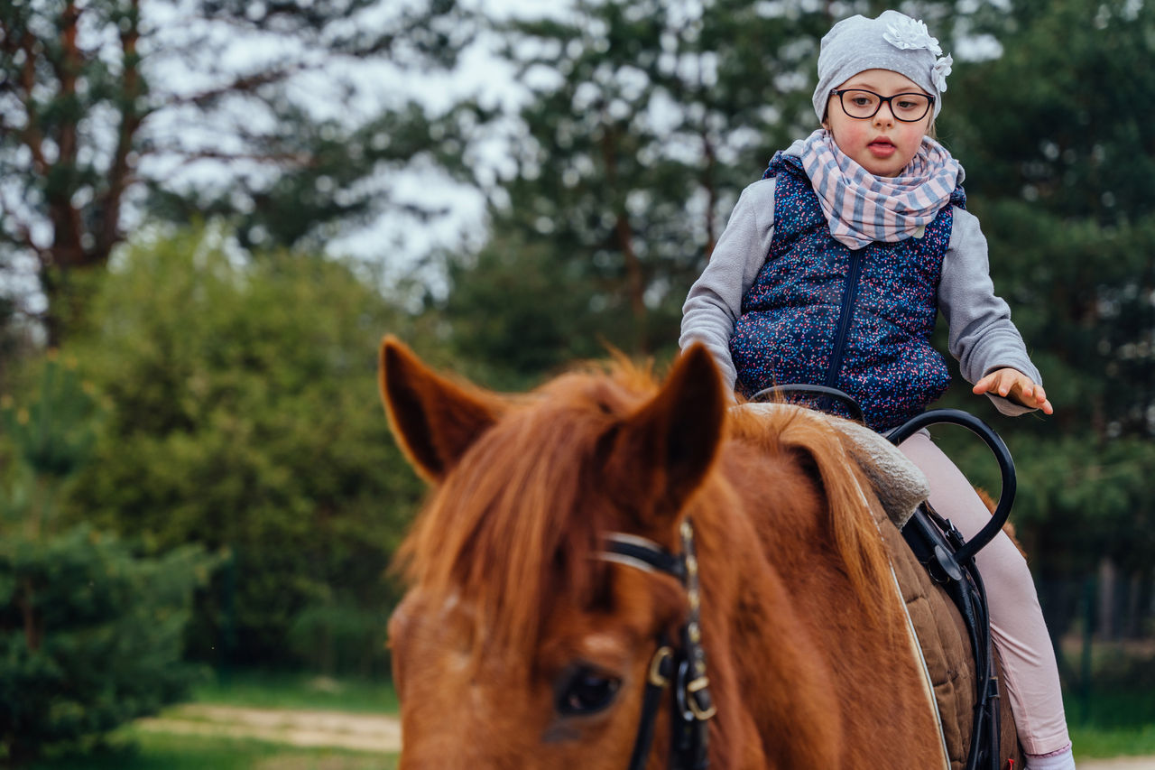 Young girl riding on horseback