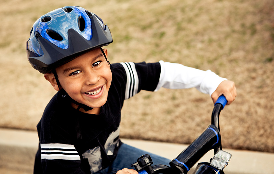 Young smiling boy on a bicycle wearing a safety helmet. Young smiling boy on a bicycle wearing a safety helmet.