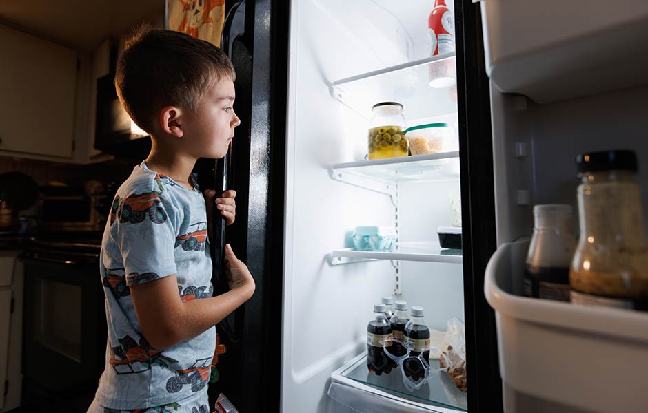 Child looking in a refrigerator