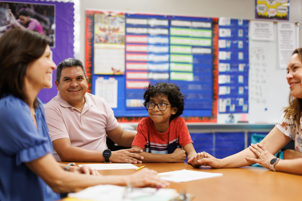 Parents and child at school conference. 