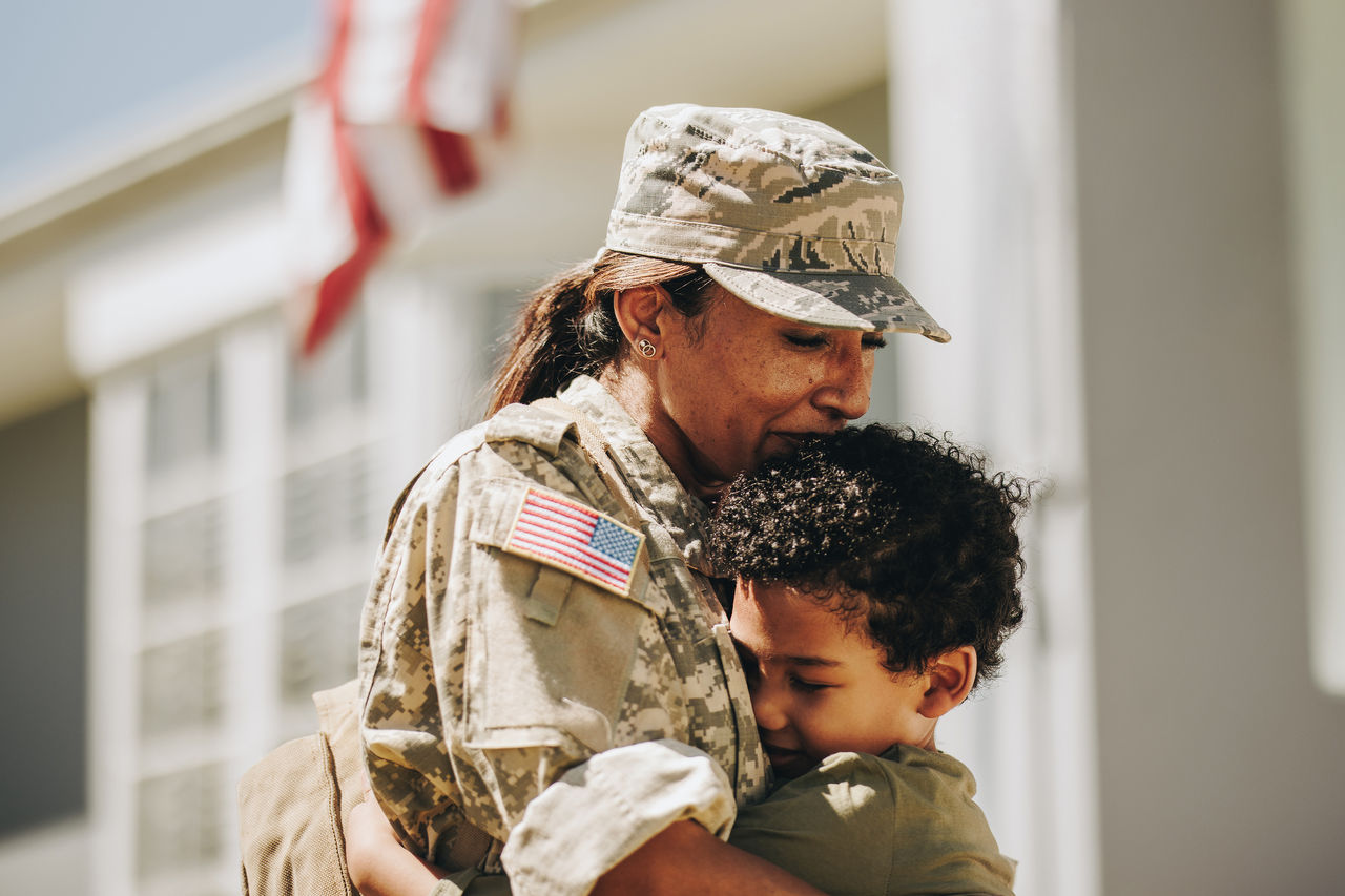 Military mother hugging child