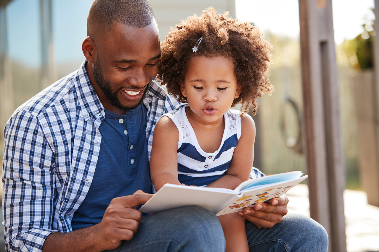 Father reading to daughter.