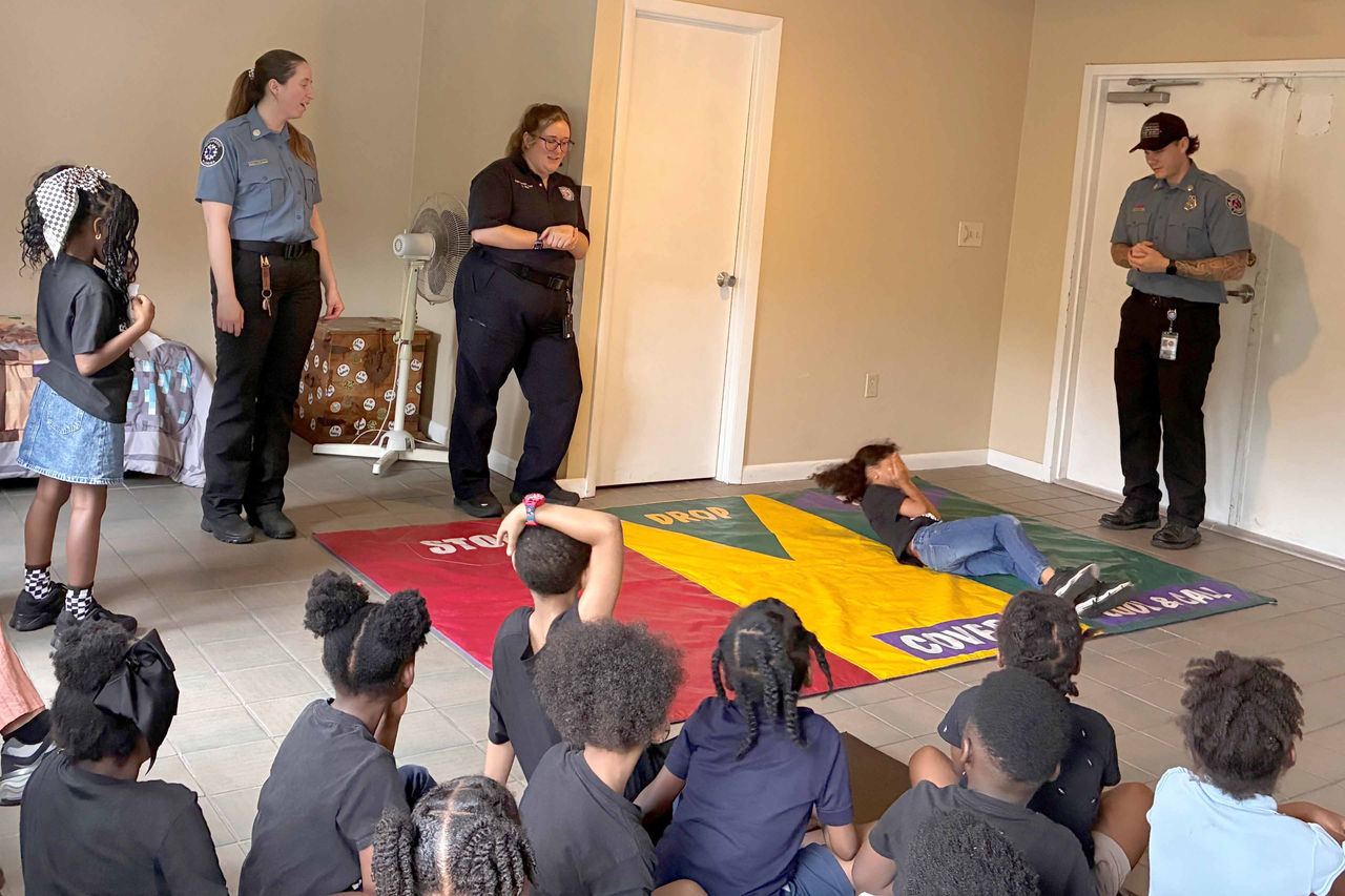 Students practice “stop, drop, and roll” and safe exit techniques with Orange County Fire Rescue